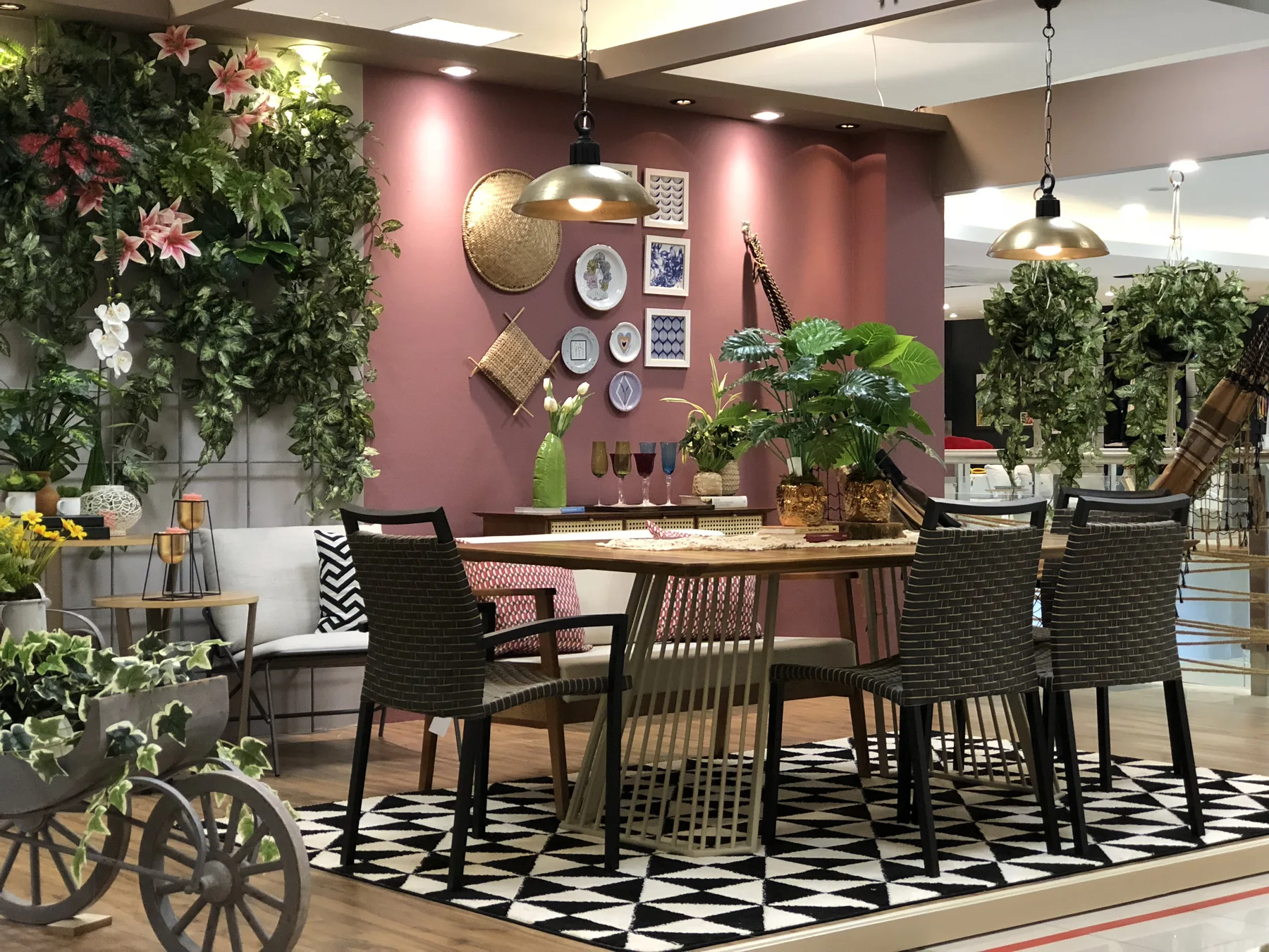 Varanda da Bossa Urbana com mesa, jardim vertical e parede rosada