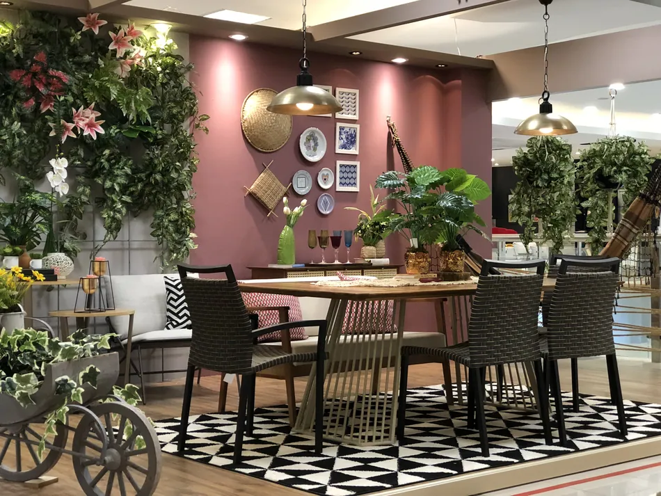 Varanda da Bossa Urbana com mesa, jardim vertical e parede rosada