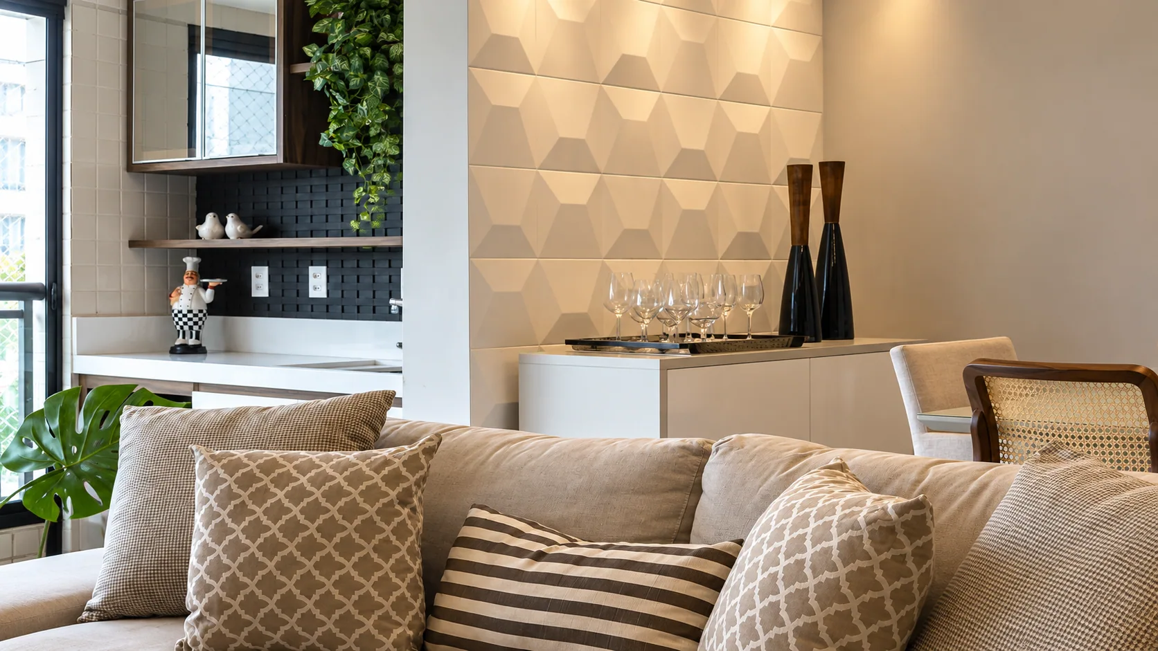 Detalhe da sala com sofá, parede texturada e aparador