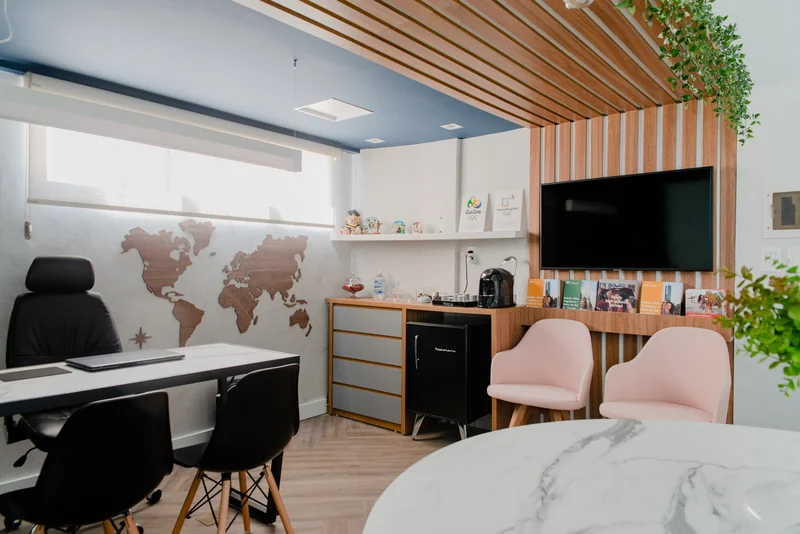 Interior da Easy EF com mapa-múndi, ripado de madeira e poltronas rosa