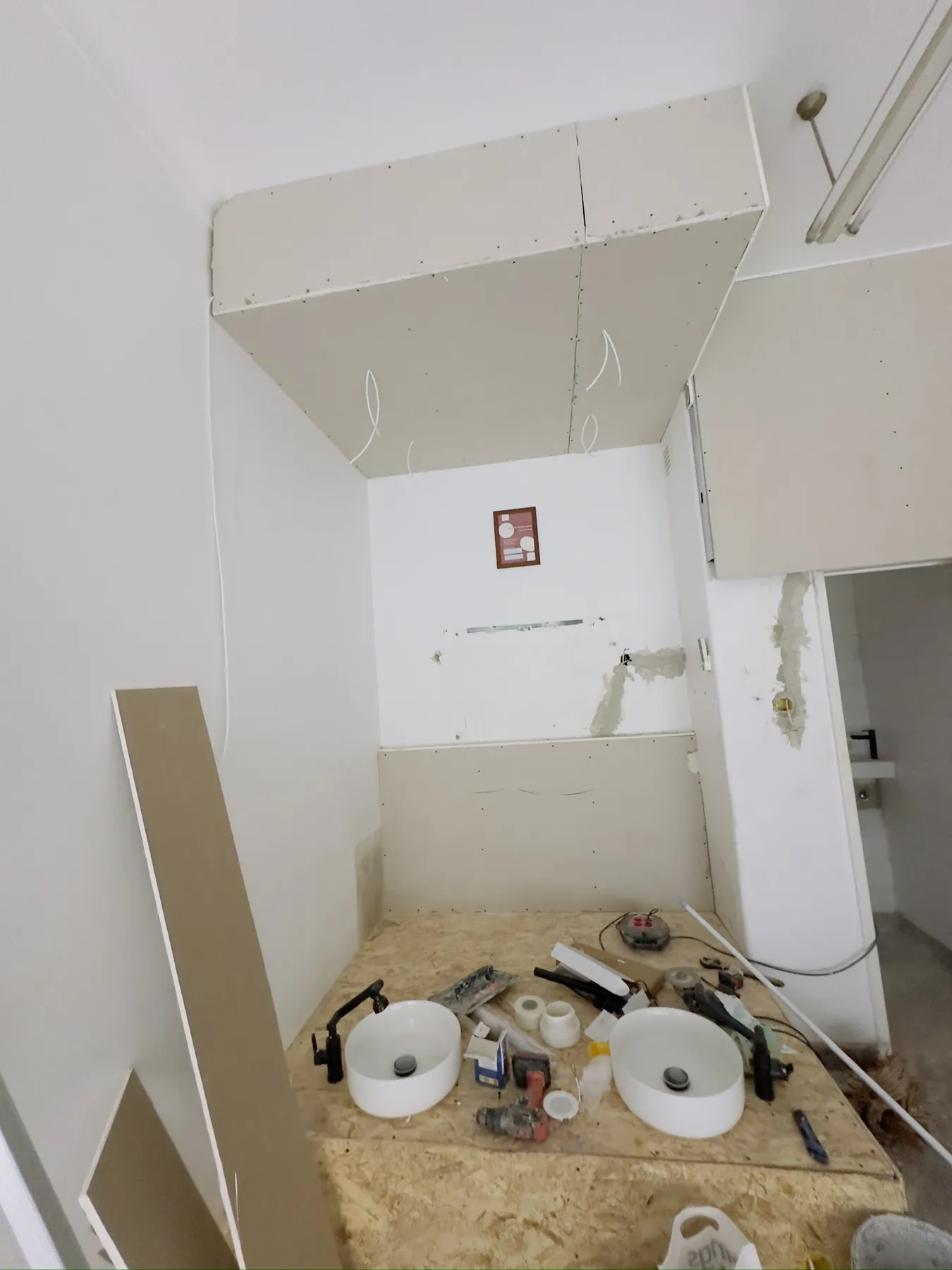O canto da pedicure em obra, com o teto falso em gesso cartonado e o estrado por revestir